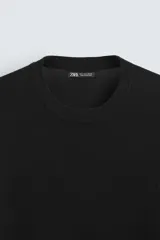 Jersey color crudo de tejido de punto, con cuello redondo y mangas largas. Corte amplio y terminaciones en rib.