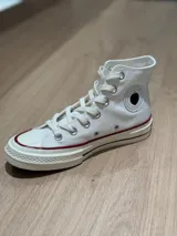 Zapatillas de lona blancas de caña alta con cordones.