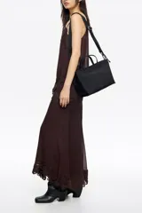 Bolso de mano Bimba y Lola de tamaño mediano, con estructura blanda, doble asa de mano y asa regulable de tejido. Cuenta con cierre de cremallera, detalles metálicos y logo de la marca en el frente.