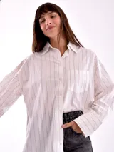 Camisa blanca con rayas verticales finas color beige, de corte amplio y mangas largas con puños abotonados.