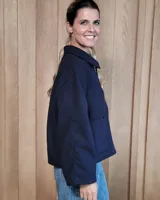 Chaqueta de textura bouclé en color bordó, con corte oversize, cuello camisero, cierre frontal y bolsillos laterales.