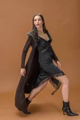 Saco largo de viscosa con caída fluida y cuello de piel sintética desmontable. Presenta un diseño abierto, ideal para superposiciones, con un corte que estiliza la silueta.