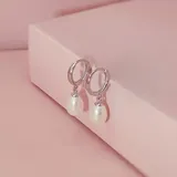 Par de caravanas tipo argolla pequeña en plata 925, con un dije colgante de perla de río natural en forma de gota.