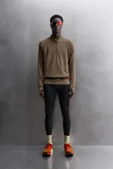 Sudadera negra de tejido técnico Polartec© con interior en estructura waffle. Tiene cuello alto con cremallera, mangas largas con puños ajustables con abertura para el pulgar y logo Polartec© bordado en el hombro.