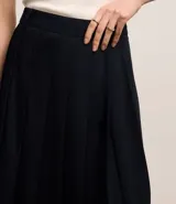 Falda midi evasé de sastrería color negro, con efecto plegado.