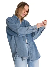 Camisa oversize de denim azul de la marca Cat, de manga larga con puños abotonados, cuello camisero y cierre frontal de botones. Presenta doble bolsillo en el pecho con etiqueta de la marca y dobladillo tipo cola de camisa.