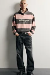 Jeans de denim de algodón en color azul con efecto desgastado, tiro medio y corte recto de ajuste holgado (loose fit). Cuenta con diseño clásico de cinco bolsillos y cierre frontal con cremallera y botón.