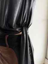Top asimétrico negro de tul brillante elastizado, con diseño de corte irregular y caída en punta.