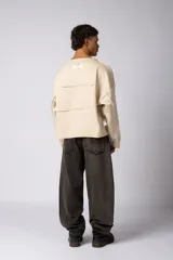 Buzo oversize de corte boxy, confeccionado en algodón rústico de alto gramaje en color beige. Presenta cuello redondo con borde crudo, mangas largas y una estampa frontal con el texto VCP delimitado por líneas horizontales blancas.