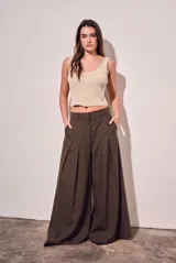 Pantalón wide leg de tiro alto color marrón oscuro, confeccionado en mezcla de viscosa y lino. Cuenta con bolsillos laterales y pinzas frontales que aportan amplitud y movimiento.