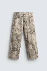 Pantalón de corte relajado confeccionado en algodón, con diseño de efecto lavado y estampado abstracto en tonos grises y beige. Presenta cinco bolsillos y cierre frontal con cremallera y botón.