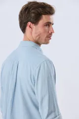 Camisa de manga larga confeccionada en mezcla de lino y algodón, con diseño de rayas finas, cuello camisero y cierre frontal de botones.