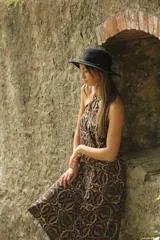 Vestido largo de corte recto con estampado abstracto en tonos marrón y beige, cuello halter y espalda descubierta.