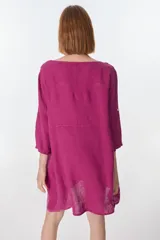 Vestido corto color beige de lino, con cuello redondo, corte oversize y mangas 3/4 con botón. Presenta bolsillos laterales.