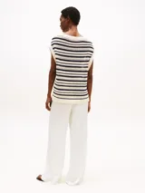 Sweater sin mangas de punto calado a rayas horizontales color crema y azul marino, con cuello barco y logo metálico de Tommy Hilfiger en el bajo.