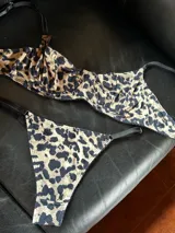 Conjunto de lencería con estampado animal print, compuesto por un corpiño con aros y breteles ajustables, y una bombacha tipo tanga con tiras laterales regulables.