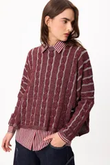Sweater de punto con diseño de trenzas verticales en color bordó y gris, de corte cropped y manga larga.