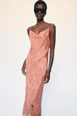 Vestido largo de Zara Woman Collection confeccionado en hilatura de viscosa, con diseño jacquard floral y escote fluido con tirantes finos ajustables. Presenta una abertura en el bajo con aplicación de encaje a tono.