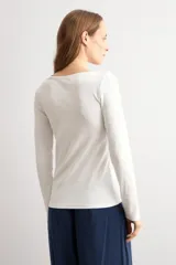 Remera de manga larga en color blanco, con escote bote y corte ajustado al cuerpo.