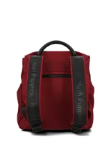 Mochila de poliéster color bordó con detalles en cuero sintético negro. Presenta solapa con correas decorativas y broches imantados, cierre principal con cremallera, bolsillo frontal con cierre, asa superior y correas ajustables.