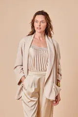 Musculosa color beige de satén plisado con puntilla de encaje en el escote y breteles finos regulables.