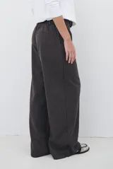 Pantalon de corte sastrero y pierna ancha, confeccionado en tela melange. Presenta cintura con trabillas, cierre frontal con botón y bolsillos laterales.