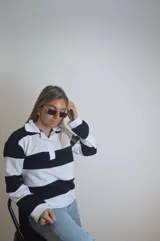 Remera estilo rugby de manga larga con cuello blanco y rayas horizontales negras y blancas.