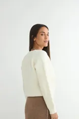 Cardigan negro de tejido de punto, con escote en V, manga larga y cierre frontal con tres botones dorados grandes.