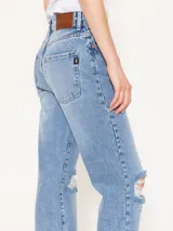 Pantalón de jean corte recto con roturas en las rodillas, de tiro medio y color azul lavado.