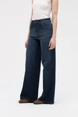 Jean de corte wide leg con tiro medio, confeccionado en denim azul oscuro con lavado uniforme. Presenta diseño de cinco bolsillos, cierre frontal con botón y cremallera, y perneras amplias y holgadas desde la cadera hasta el bajo.