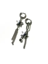 Aros colgantes asimétricos de acero quirúrgico plateado, con diseño de argolla, dijes en forma de estrella tridimensional, cadenas colgantes y una pequeña esfera metálica.