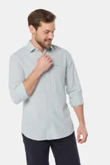 Camisa de manga larga, corte slim fit, color celeste con finas rayas verticales blancas. Presenta cuello camisero y un pequeño logo bordado en el pecho.