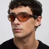 Lentes de sol con diseño envolvente de estilo deportivo y retro, con montura color camel y cristales de color naranja.