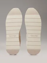 Zapatillas Calvin Klein de perfil bajo, confeccionadas en una combinación de ante, piel y lona en tonos beige. Presentan un diseño minimalista con suela de caucho y logo de la marca estampado en el lateral.