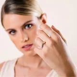 Anillo en forma de V fabricado en plata 925, con engaste de pequeñas circonias brillantes a lo largo de la banda.