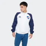 Campera deportiva Umbro del Club Nacional de Football modelo Venti, con capucha y cierre frontal completo. Diseño en color blanco con mangas azules, puños elásticos y detalles en rojo. Incluye el logo de Umbro y el escudo del club bordados en el pecho.