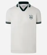 Remera polo comfort color crudo, de manga corta con ribete verde y cuello en V con ribete verde. Tiene un pequeño logo bordado en el pecho.