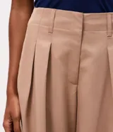 Bermuda de sastrería color negro con diseño amplio, pinzas frontales, trabillas para cinturón y cierre clásico.