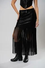 Falda midi negra de cuero sintético con flecos largos y abertura lateral.