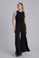 Remera sin mangas negra, ajustada al cuerpo, con cuello redondo y detalles de tachas metálicas plateadas a lo largo de los hombros y sisas.