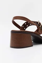 Sandalias de taco cuadrado en color whisky, con tiras decoradas con tachas y hebillas metálicas en tono bronce, y tira ajustable en el talón.