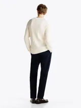 Sweater de punto trenzado color blanco con cuello redondo, mangas largas y detalles acanalados en puños y bajo, de la marca Tommy Hilfiger.