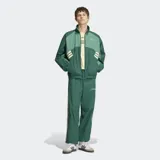 Campera deportiva Adidas Múnich 93 en tonos de verde, con cuello alto, cierre frontal y las icónicas tres tiras en las mangas. Diseño holgado con detalles en contraste.