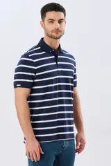 Remera polo de manga corta con diseño de rayas horizontales en color azul marino y rosado. Cuenta con cuello camisero, cierre frontal con botones y calce clásico.