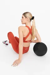 Top deportivo color ladrillo, de compresión alta, con espalda cruzada y breteles anchos.