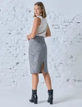 Falda de corte recto confeccionada en tejido tweed de la marca Zac & Rachel. Presenta cintura elastizada, bolsillos delanteros simulados con botones y un tajo en el ruedo trasero.