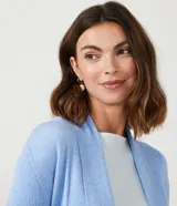 Cardigan largo de punto texturizado color ladrillo, con abertura frontal y terminación en puntas.