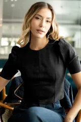 Top corto color verde militar, marca Tahari, confeccionado en símil gamuza. Tiene mangas cortas abullonadas, cuello redondo y cierre invisible en la espalda.