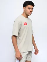 Remera de corte holgado color celeste, con cuello redondo diferenciado y logo de la marca estampado en el pecho. Presenta un diseño de manga corta y estilo deportivo.