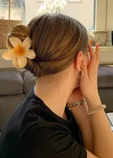 Pinza para el pelo color crema con forma de flor hawaiana.